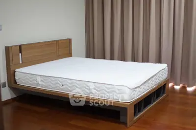 Spacious bedroom with modern wooden bed frame and elegant curtains