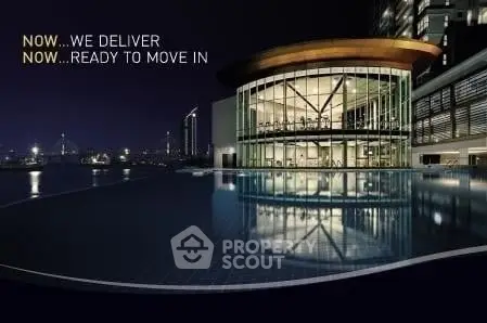 Stunning modern building with illuminated glass facade and infinity pool at night.