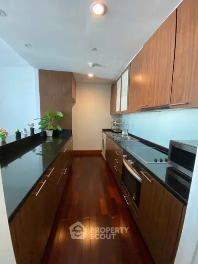 Modern kitchen with sleek wooden cabinets and dark countertops