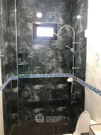 Modern bathroom with elegant marble tiles and sleek shower design.