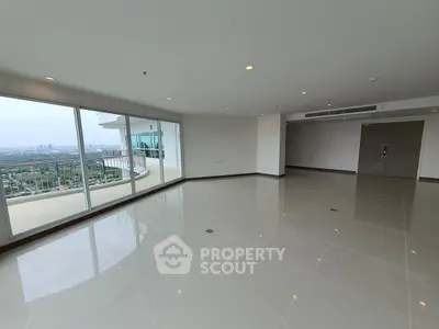 Spacious modern living room with panoramic city view and large balcony access.
