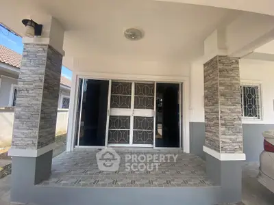 Charming home entrance with modern stone pillars and tiled steps