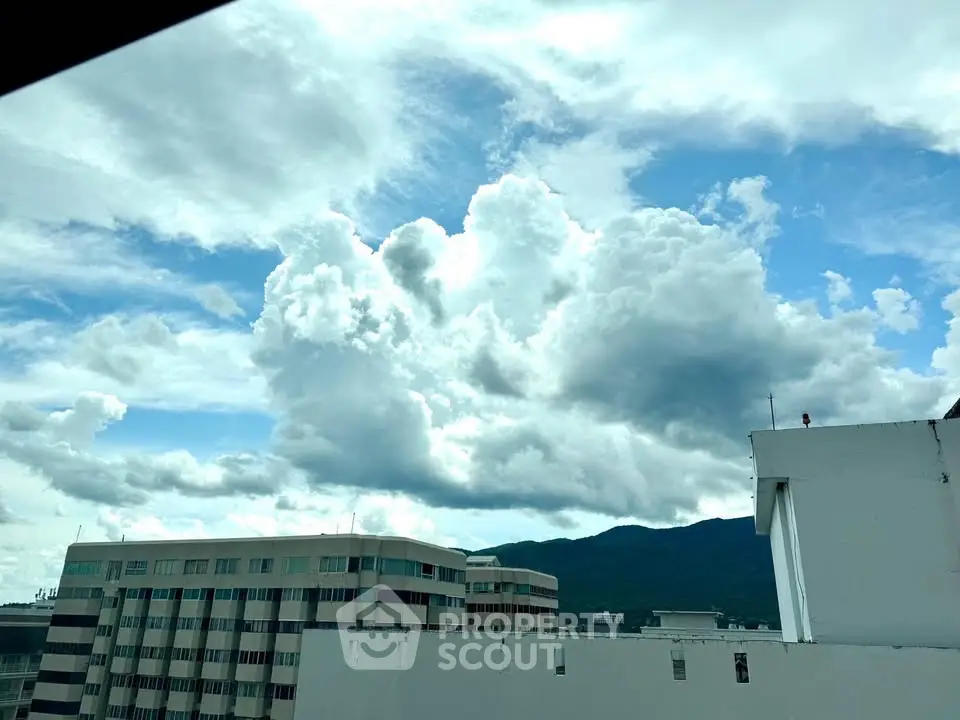 Stunning cityscape view with dramatic clouds over modern buildings.