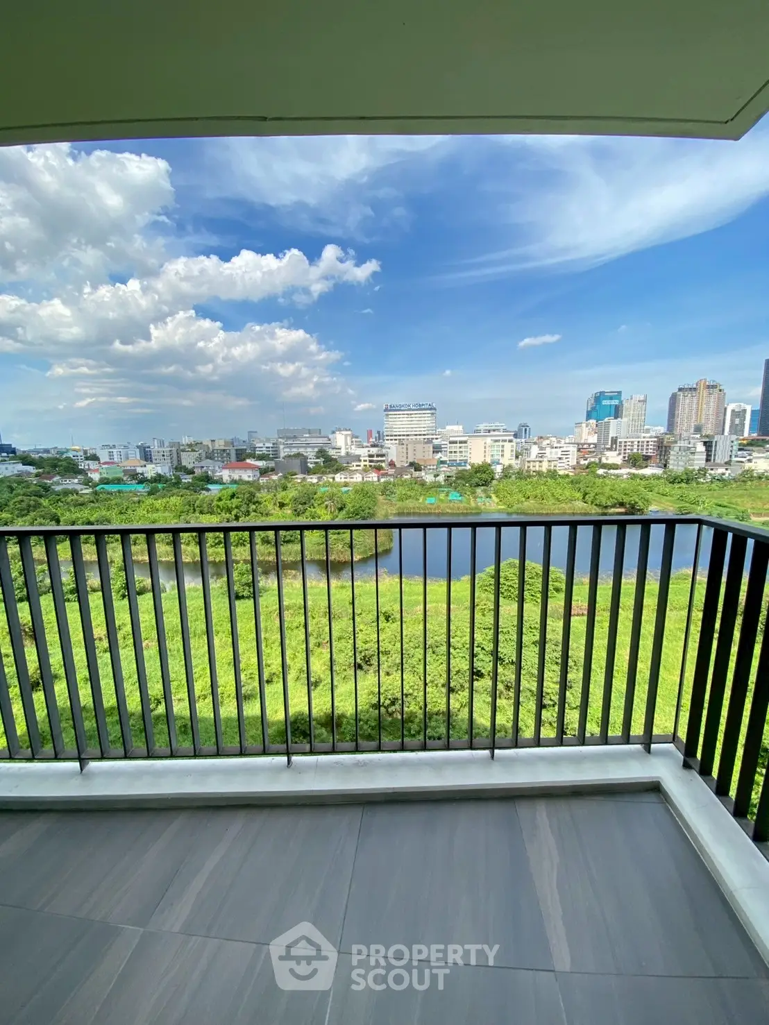 Stunning balcony view overlooking lush greenery and city skyline, perfect for urban living.