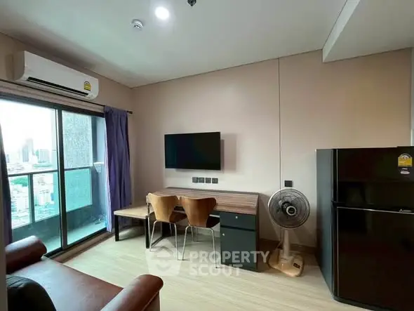 Modern living room with balcony view, sleek furniture, and air conditioning.