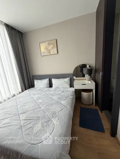 Cozy bedroom with modern decor and natural light, featuring a stylish vanity and elegant bedding.