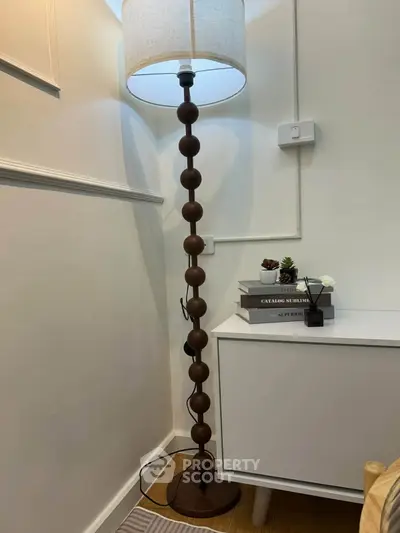 Stylish modern living room corner with unique floor lamp and chic side table.