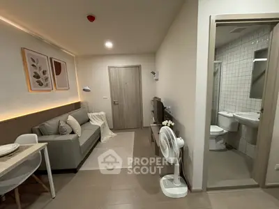 Modern living room with cozy sofa and adjacent bathroom in stylish apartment