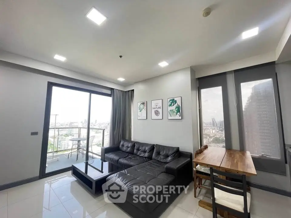 Modern living room with city view, featuring sleek furniture and large windows for natural light.
