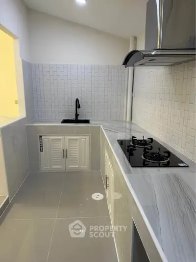 Modern kitchen with sleek countertops and gas stove in a stylish home.
