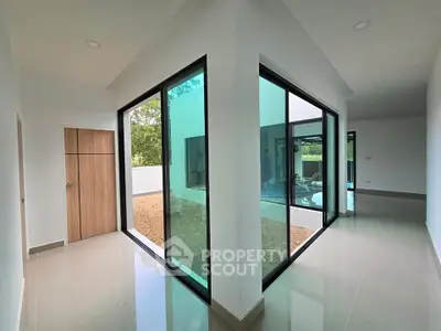 Modern interior with large glass sliding doors and sleek tile flooring, offering a seamless indoor-outdoor transition.