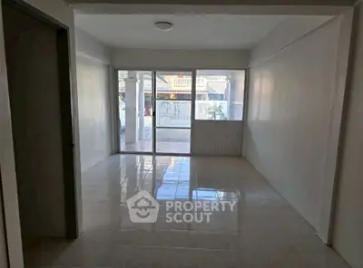 Spacious empty room with large windows and tiled flooring, ideal for customization.