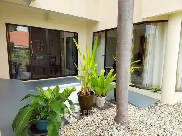 Charming courtyard with lush plants and large windows in a modern home