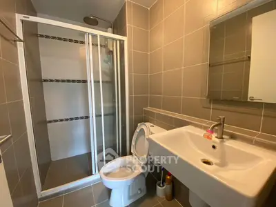 Modern bathroom with sleek shower and stylish sink in contemporary home.