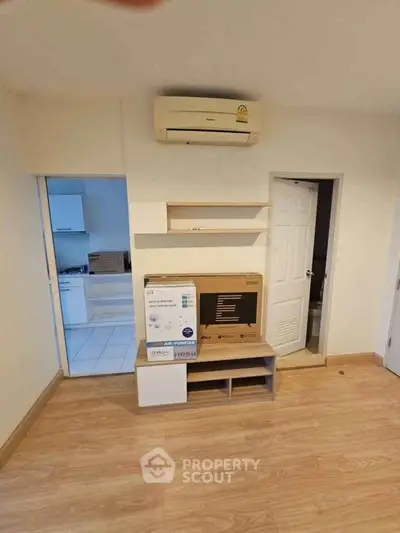 Cozy living room with wooden flooring and modern air conditioning unit, perfect for comfortable living.