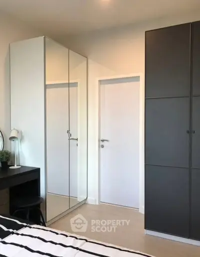 Modern bedroom with sleek mirrored wardrobe and minimalist decor