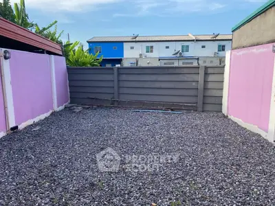 Spacious gravel courtyard with colorful walls, perfect for outdoor activities.