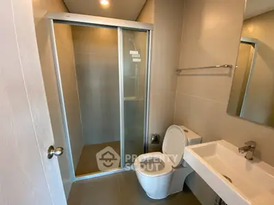 Modern bathroom with sleek shower and contemporary fixtures in a stylish apartment.