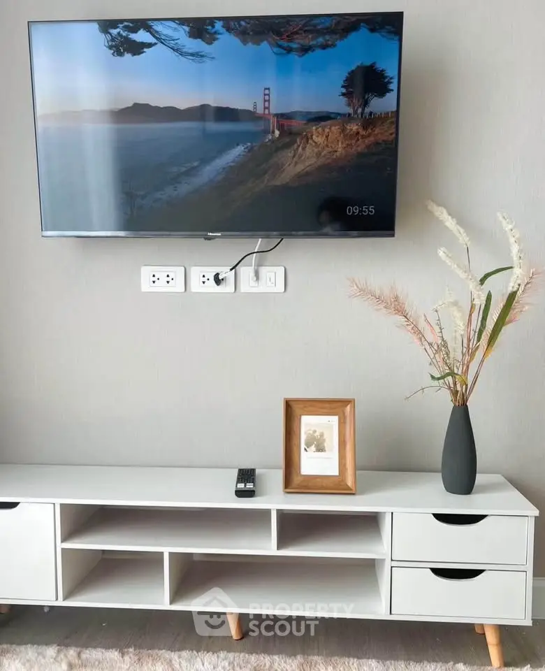 Modern living room with wall-mounted TV and stylish console table.