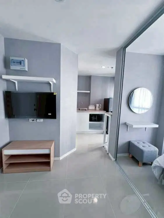 Modern studio apartment with sleek design and open layout, featuring a wall-mounted TV and stylish decor.