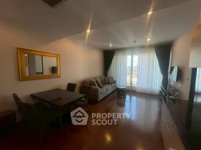 Spacious living room with elegant decor and large window offering natural light and city view.