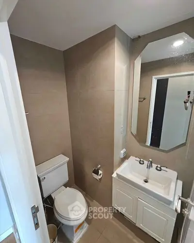 Modern bathroom with sleek fixtures and neutral tones, featuring a compact design ideal for urban living.