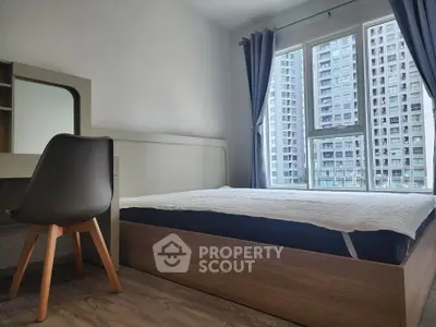 Modern bedroom with large window and city view, featuring sleek furniture and cozy ambiance.