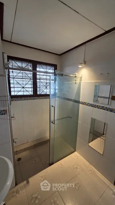 Spacious bathroom with glass shower and decorative tiles