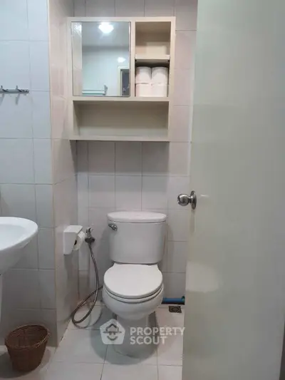 Compact bathroom with modern fixtures and storage shelves.