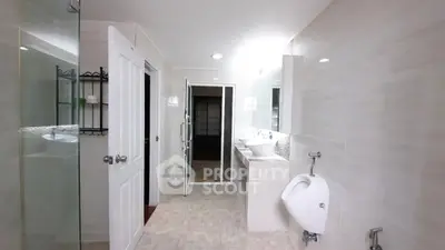 Spacious modern bathroom with dual sinks and glass shower enclosure