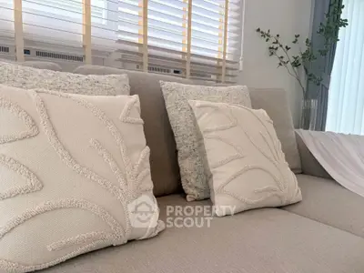 Elegant living room with stylish beige sofa and decorative pillows, perfect for modern comfort.