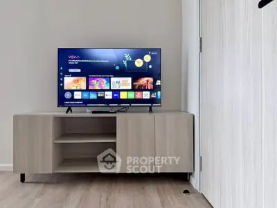 Modern living room with sleek TV stand and flat-screen television displaying streaming apps.