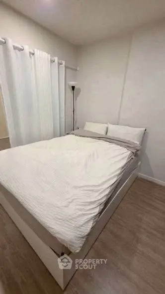 Cozy bedroom with modern decor and natural light, perfect for relaxation.