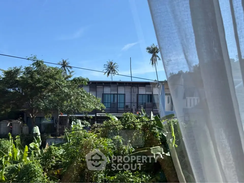 Charming residential view with lush greenery and modern architecture under clear blue sky.