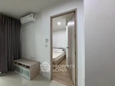 Modern apartment interior with air-conditioned living area and cozy bedroom view.