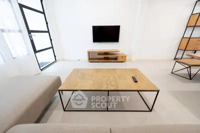 Modern living room with minimalist furniture and wall-mounted TV