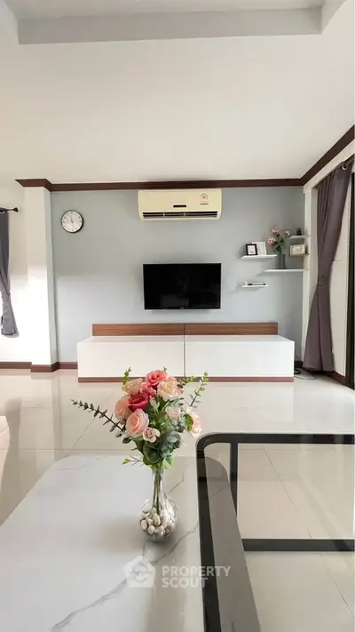 Modern living room with sleek TV setup and elegant floral centerpiece