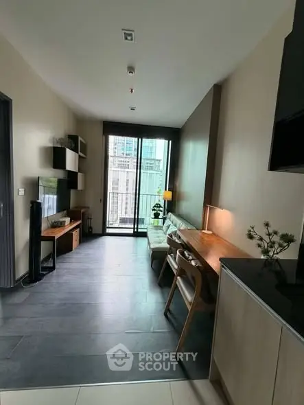 Modern living room with sleek furniture and large windows offering city views.