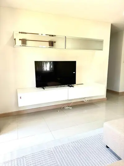 Modern living room with sleek TV setup and glossy floor tiles