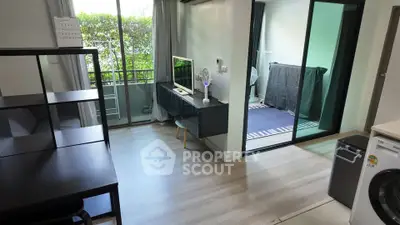 Modern living room with balcony and laundry area, featuring sleek furniture and natural light.