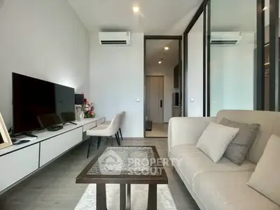 Modern living room with sleek furniture and large TV, perfect for relaxation and entertainment.