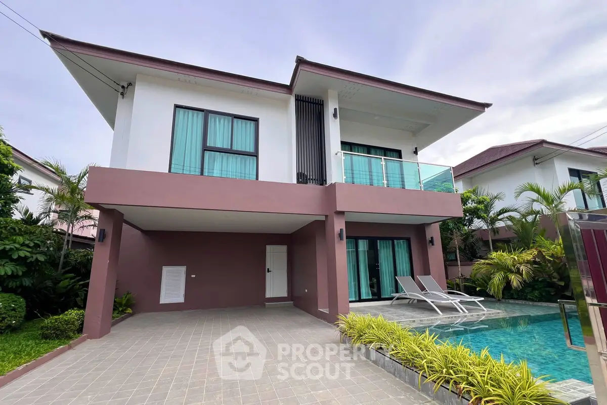 Modern two-story house with pool and balcony in tropical setting