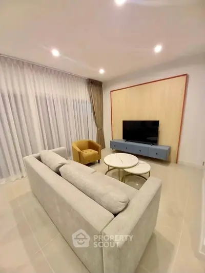 Modern living room with stylish furniture and large window drapes