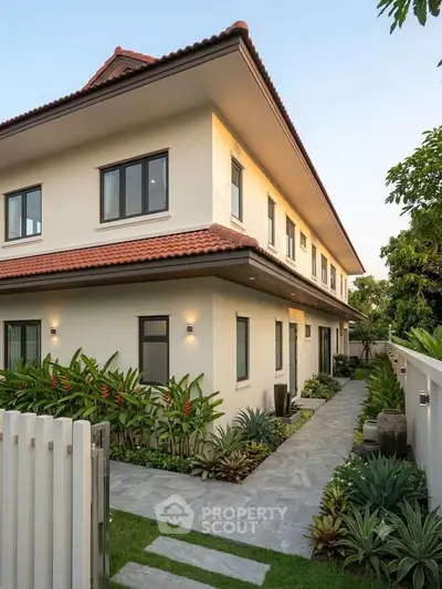 Elegant two-story house with lush garden and modern exterior design.