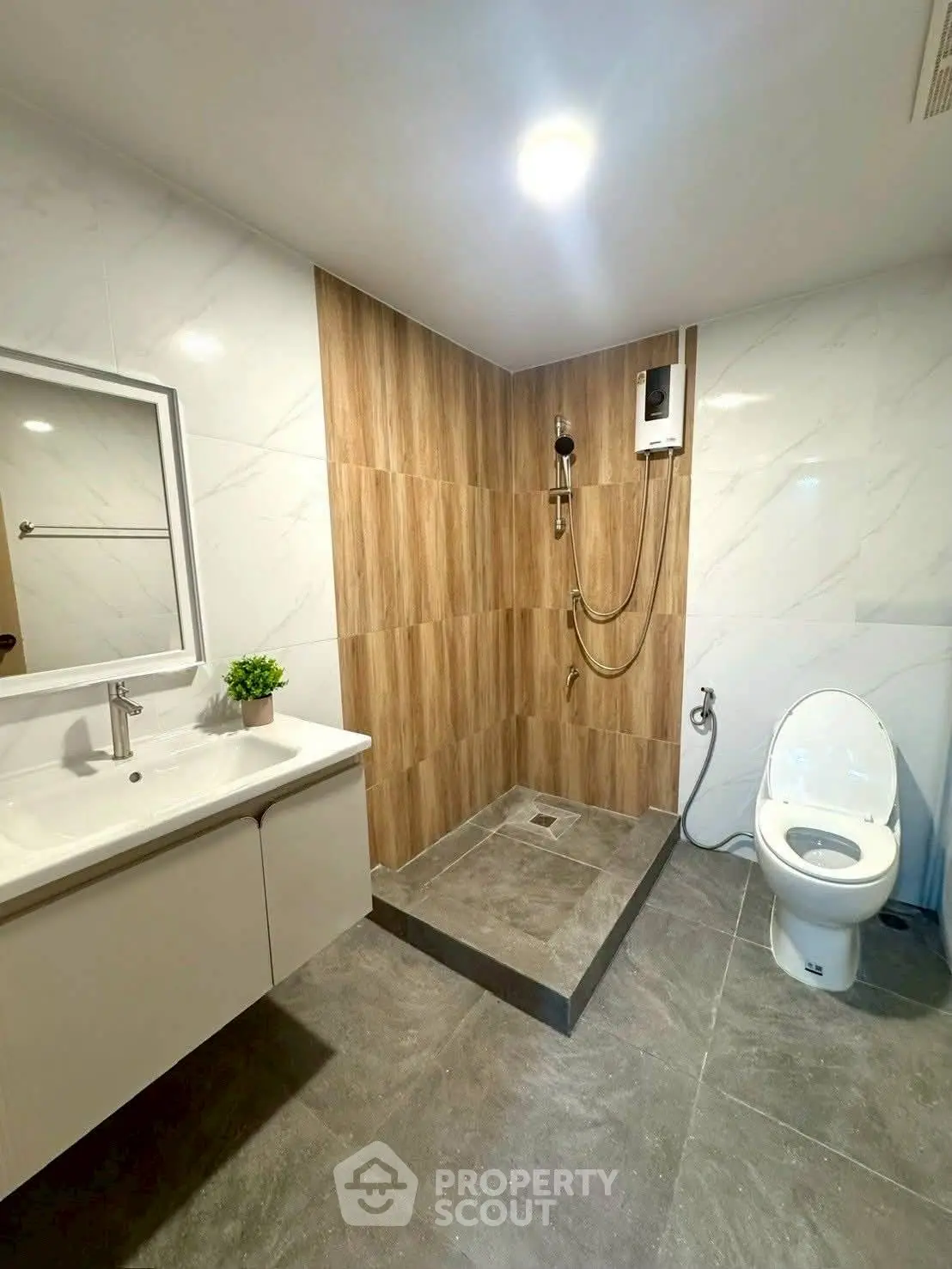 Modern bathroom with sleek design, featuring a shower area, toilet, and stylish vanity.