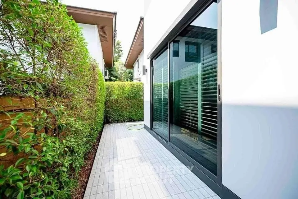 Modern patio with sliding glass doors and lush greenery