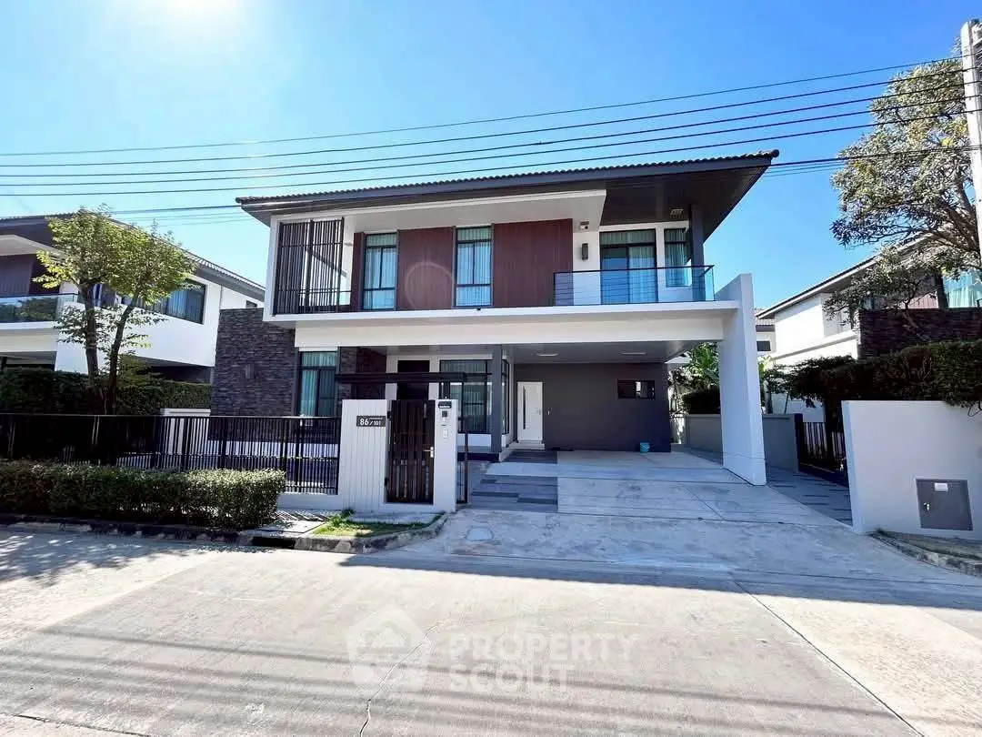 Modern two-story house with sleek design and spacious driveway in a serene neighborhood.