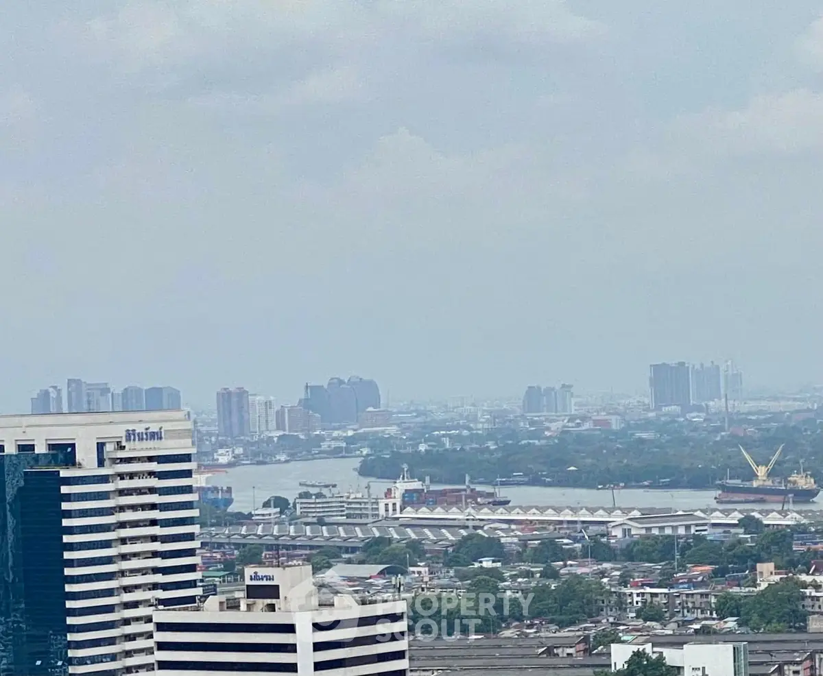 Stunning cityscape view from high-rise building showcasing urban skyline and river.