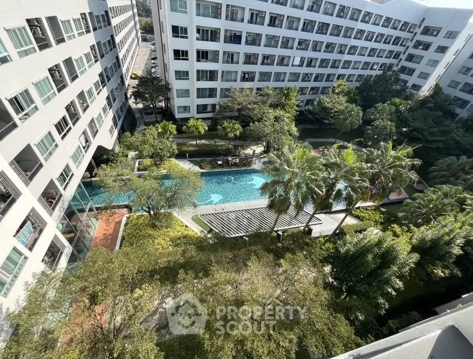 Stunning aerial view of modern apartment complex with lush gardens and inviting swimming pool.