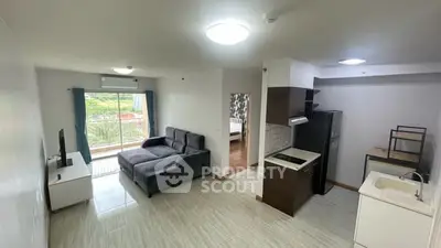 Modern open-layout living room with kitchen and balcony view